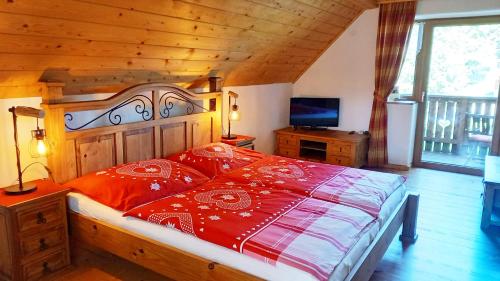 a bedroom with a bed with a red comforter at Biohof Prannleithen - Knusperhaus in Yspertal