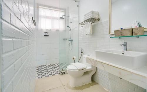 a bathroom with a toilet and a sink and a shower at The Mansion Boutique Hotel in Mabalacat