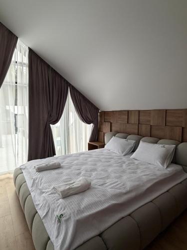 a bedroom with a large bed with two towels on it at Goldhill villa in Yaremche