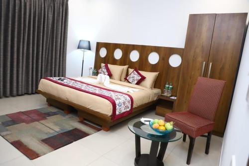 a bedroom with a bed and a table and a chair at Nivasaah in Jāmb