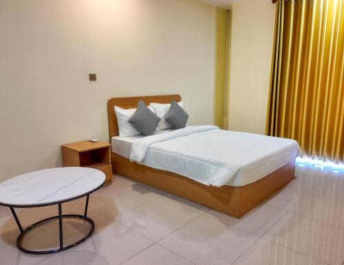 a bedroom with a large bed and a table at Bolyno Skyline Hotel in Phnom Penh