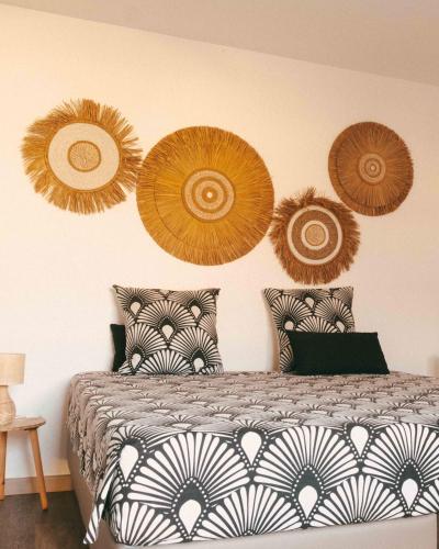 a bedroom with a bed with paper plates on the wall at Chambre d'hôte La Kazanou in Saint-Joseph