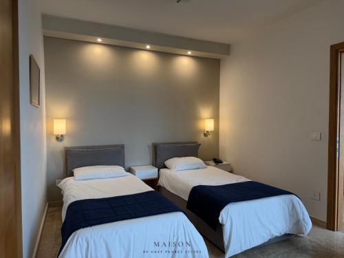 a room with two beds in a room at Maison by Grey Pearls Suites in Mīnāʼ al ‘Atīqah