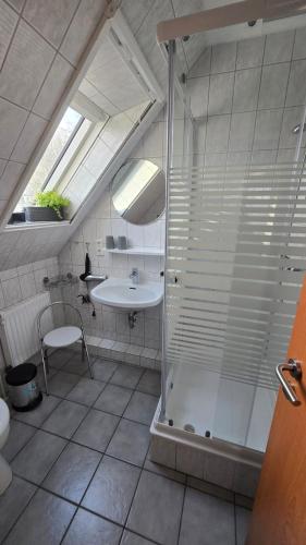 a bathroom with a shower and a sink at Pension Sandra in Neuharlingersiel