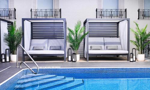 two chairs sitting next to a swimming pool at The Brock Niagara Falls Fallsview, Tapestry by Hilton in Niagara Falls
