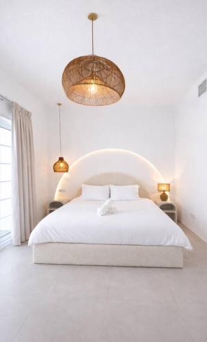 a white bedroom with a white bed and two lights at Dubai Escape Private Pool and Parking in Dubai