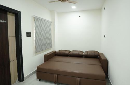 a couch in a room with a ceiling fan at Aacasa Living Resorts in Shamshabad