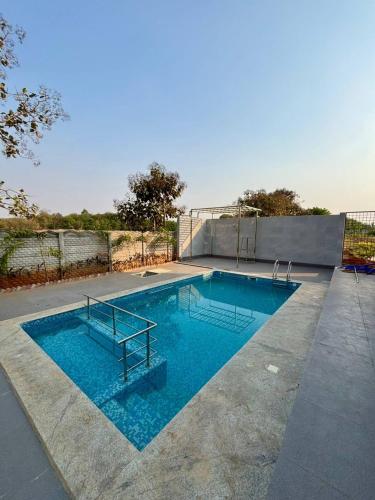 a swimming pool with a bench in the middle of it at Aacasa Living Resorts in Shamshabad