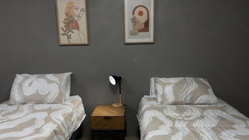 a bedroom with two beds and a table with a lamp at 42AtSouth in Vryheid
