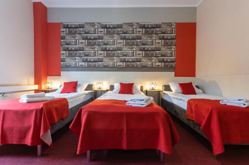 a hotel room with two beds with red sheets at Hotel Przystanek Torun in Toruń
