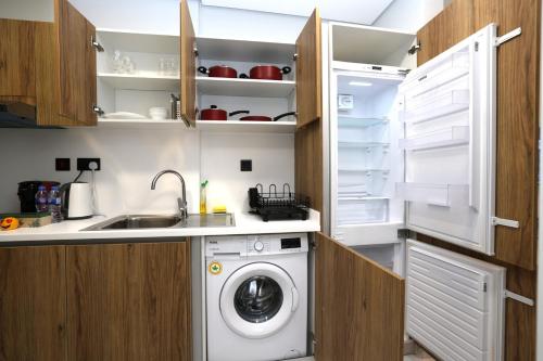 a kitchen with a washing machine and a sink at Maryah Island Studio Near Galleria Mall & ADGM in Abu Dhabi