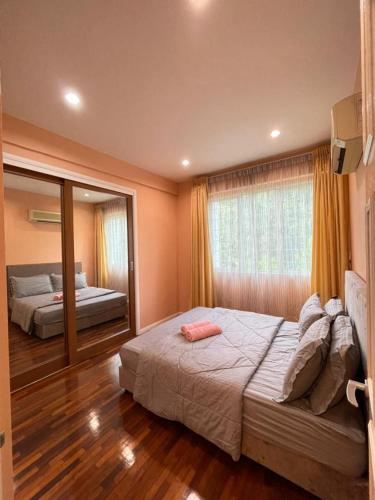 a bedroom with two beds and a large mirror at 6A SANTUBONG SUITES by MF in Kuching