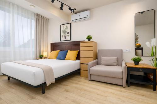 a bedroom with a bed and a chair at Beachfront Design LUX Studio Apartment in Estepona