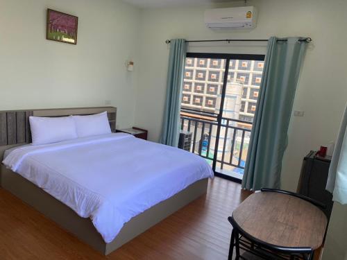 a bedroom with a bed and a large window at The Burapa Rooms in Bangkok