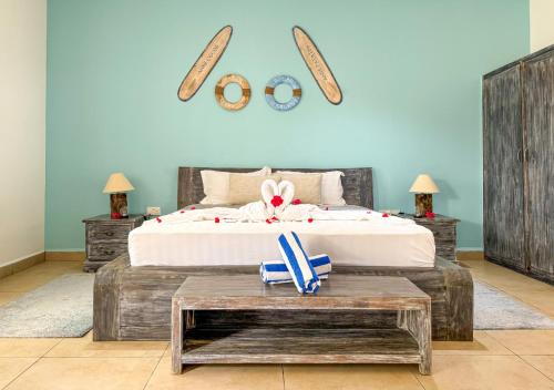 a bedroom with a bed and a table with a bench at Coral Apartments in La Digue