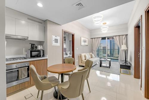 a kitchen and living room with a table and chairs at Reva Hotel Apartment Downtown in Dubai
