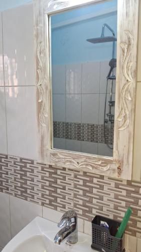 a bathroom sink with a mirror on the wall at Zai Homes Watamu in Watamu