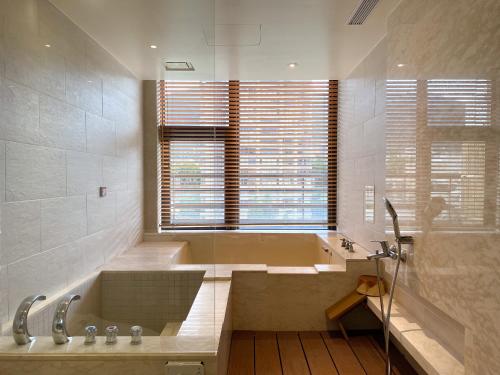 a large bathroom with a tub and a window at Beitou Sweet Me Hot Spring Resort in Taipei