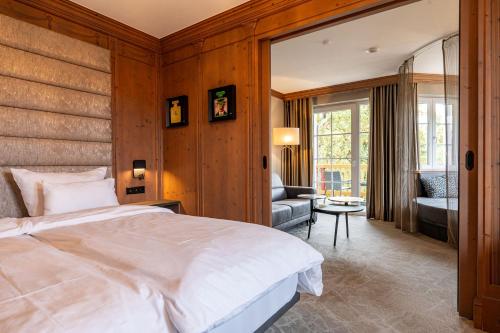 a bedroom with a large white bed and a living room at Meiser SPA Resort in Fichtenau