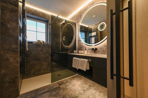 a bathroom with a shower and a sink and a mirror at Meiser SPA Resort in Fichtenau