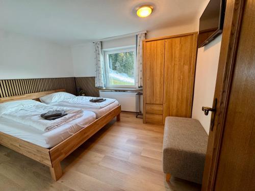 a small bedroom with a bed and a window at GO FOR MOUNTAINS Appartements in Eben im Pongau