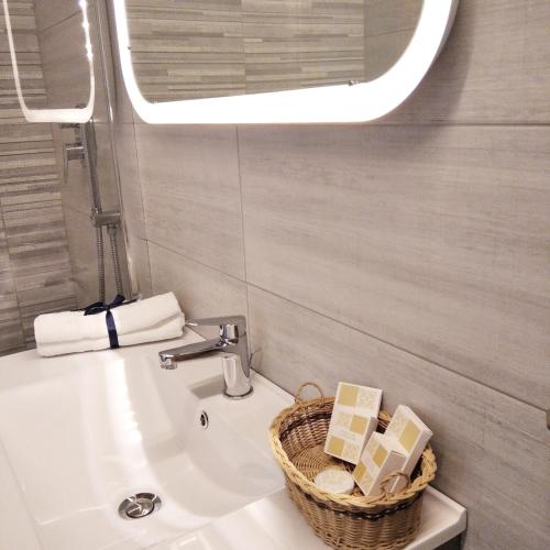 a bathroom with a sink and a basket of soap at TRANI LA GRAZIA b&b in Trani