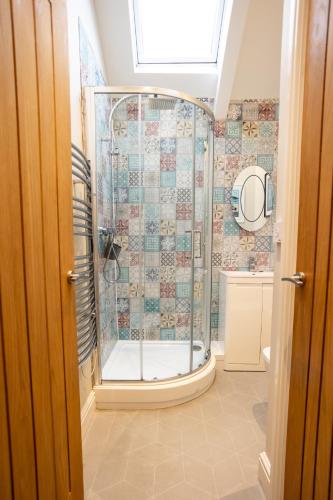 a bathroom with a shower with a glass door at Stylish Tenby Apartment, Great Location, Parking in Tenby