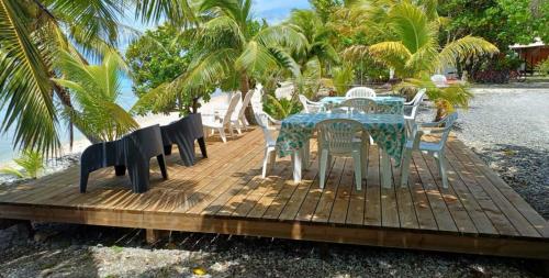a table and chairs on a wooden deck near the beach at MONITA VILLA Rangiroa in Tiputa