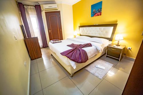 una camera da letto con un grande letto con un vestito sopra di LOUMIA Residency a Douala