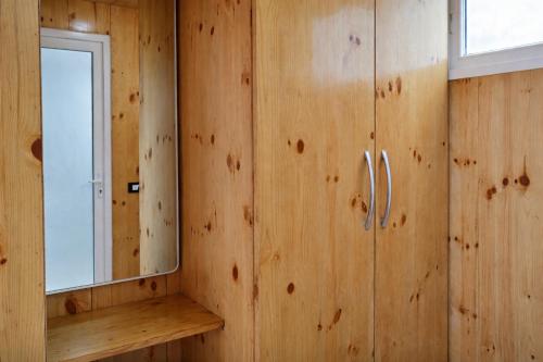 a wooden wall with a mirror and a cabinet at Pine Country Resort in Mukteshwar