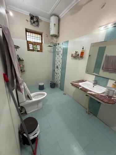 a bathroom with a toilet and a sink at Meraki Homes in Karnal