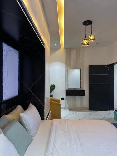 a bedroom with a large bed with a black headboard at Emerald Enclave Residence in Gwarinpa
