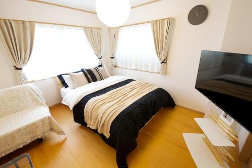a bedroom with a bed and a tv in it at 伯旺ビル 403 in Kanazawa
