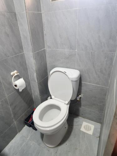 a bathroom with a toilet and a roll of toilet paper at Happy Dany Stays in Kiahuria