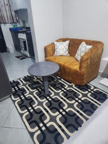 a living room with a couch and a table on a rug at Happy Dany Stays in Kiahuria