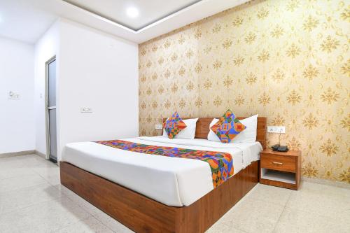 a bedroom with a large bed with white sheets at FabHotel Shivay in Indore