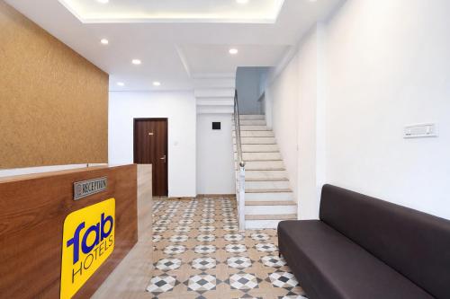 a lobby with stairs and a sign on the wall at FabHotel Shivay in Indore