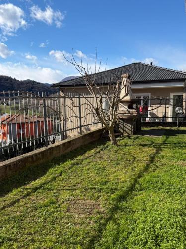 a fence in front of a house with a yard at Lily House in Luino