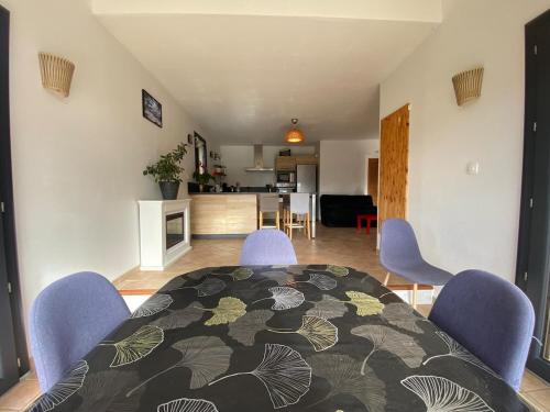 a living room with a table and chairs and a kitchen at La Villa Soleil in Veynes