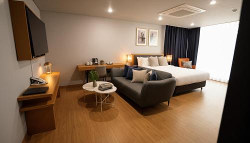 a hotel room with a bed and a couch at Kwangsu Hotel Haeundae in Busan