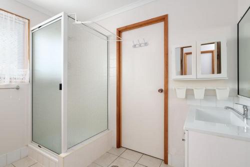 a bathroom with a glass shower and a sink at Welcome to Seascapes in Tin Can Bay