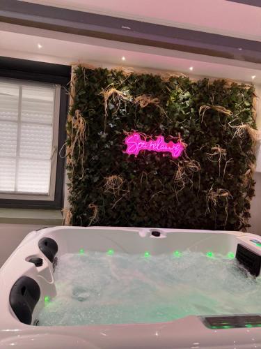 a bathtub in a bathroom with a green wall at Maison in Maisdon-sur-Sèvre