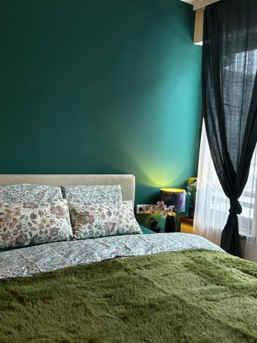 a bedroom with a green wall and a bed at Green Point Studio O12 in Chepelare