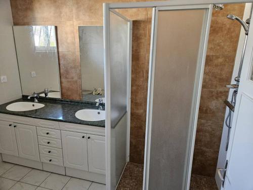 a bathroom with two sinks and a shower at La Belle des Pins in Mimizan