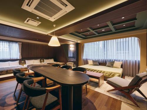 a hotel room with a bed and a table and chairs at illi Eme Tokyo-Toranomon in Tokyo