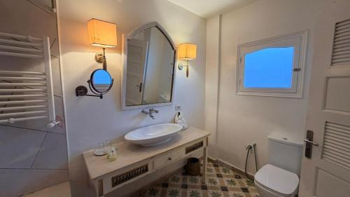 a bathroom with a sink and a toilet and a mirror at Dar Yessine Boutique Hôtel in Sousse