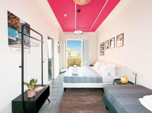 a room with two beds and a red ceiling at Ostello Bello Bologna in Bologna