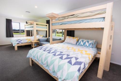 a bedroom with two bunk beds and a couch at Mahaki Escape in Pahautea