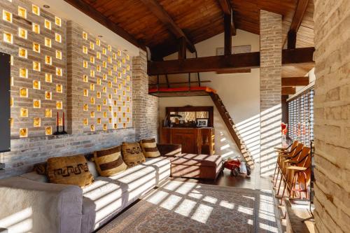 ein Wohnzimmer mit einer Couch und einer Backsteinwand in der Unterkunft Dimora Le Conce - Loft di Charme in Fabriano