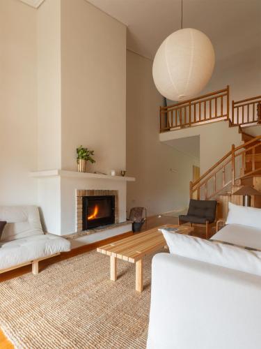 a living room with a couch and a fireplace at VYTINA LOFTS - Cozy 2-Level Loft Apartments with Fireplace & Mountain Views in Vitina